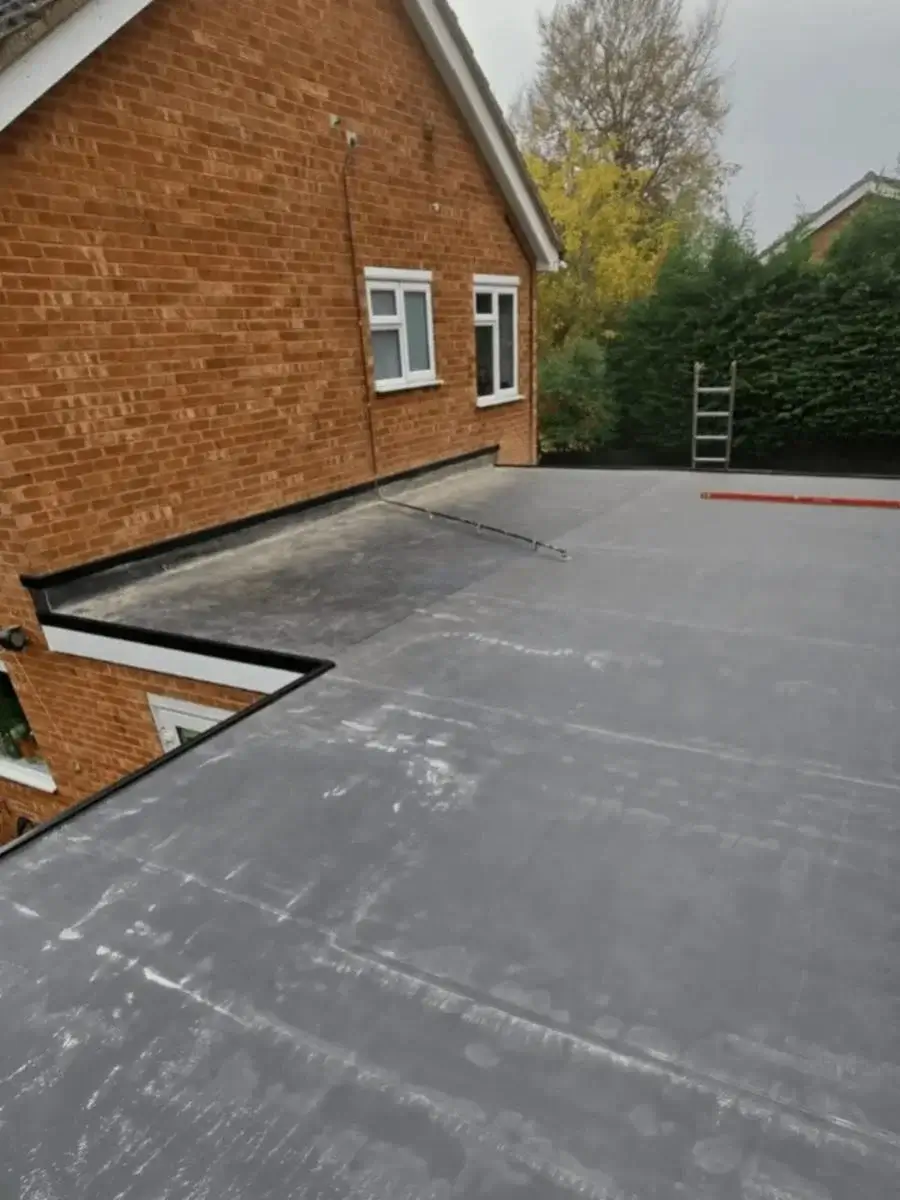 High-angle view of a completed slate grey rubber membrane flat roof detailing clean perimeter edge trims. Finished by Norfolk Exterior Solutions